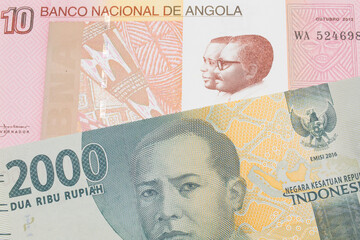 Fototapeta premium A macro image of a grey two thousand Indonesian rupiah bank note paired up with a colorful ten kwanza bank note from Angola. Shot close up in macro.
