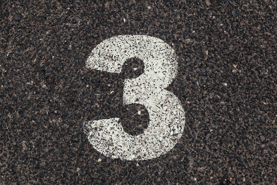 Number 3 Printed on White Over Dirty Asphalt
