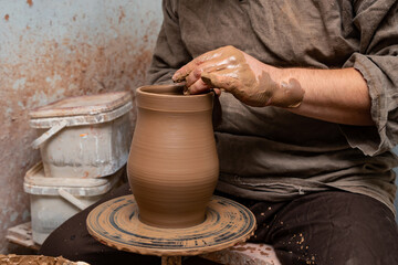 Fototapeta na wymiar Creating a pot of clay close-up. Hands making products from clay. Potter at work.