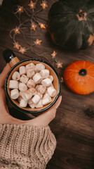 Cup of coffee with marshmallows in  hand