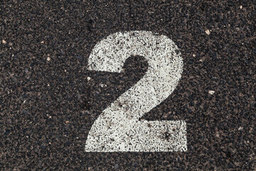 Number 2 Printed on White Over Dirty Asphalt