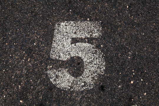 Number 5 Printed on White Over Dirty Asphalt