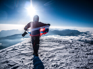 Slovakia climber standing on top of the mountain with flag of his country