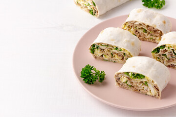 Lavash roll with fish, cheese, eggs and parsley on white background. Festive appetizer. Copy space