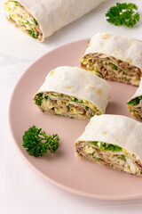 Lavash roll with fish, cheese, eggs and parsley on white background. Festive appetizer. Vertical