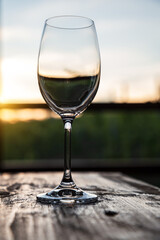 A glass of wine at sunset over the vineyards.