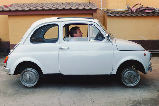 Funny Italian vintage car with driver, stuck without tires