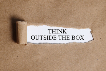 think outside the box. Text on white paper on torn paper
