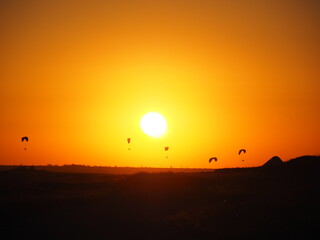 Skydivers at sunset
