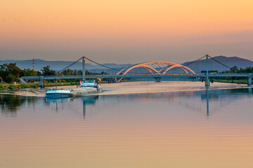 Two bridges crossing the Rhone River near Avignon.  A commercial river boat is in the foreground.