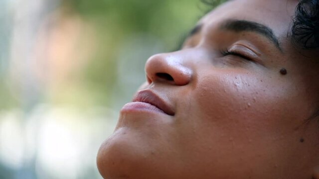 Mixed race woman closing eyes in meditation outside