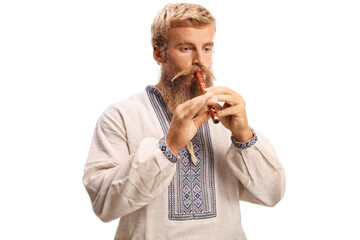 Man in ethnic clothes playing a wooden flute