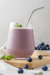 Glass of protein cocktail with blueberry on a light table.