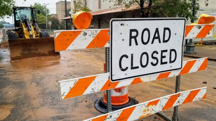 Road construction with road closed sign and bulldozer.