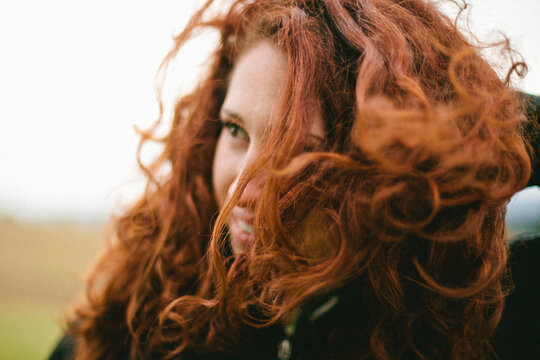 Smiling Woman with Red Curly Hair