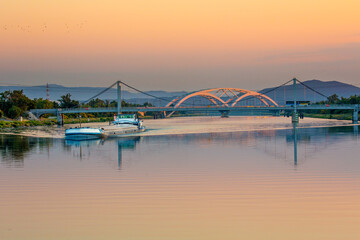 Fototapeta premium Two bridges crossing the Rhone River near Avignon. A commercial river boat is in the foreground.