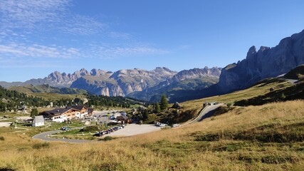 Fototapeta na wymiar Val Gardena, Italy - 09/15/2020: Scenic alpine place with magical Dolomites mountains in background, amazing clouds and blue sky in Trentino Alto Adige region, Italy, Europe