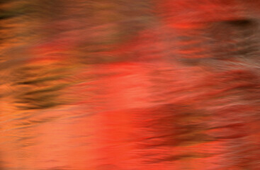 telephoto time exposure ripples on water in autumn reflecting autumn colors in vegetation