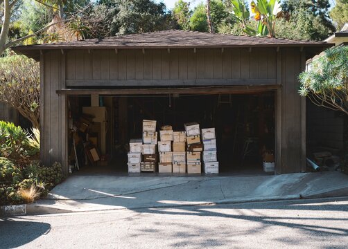 Stacked cardboard boxes filled with of documents sitting in a garage.