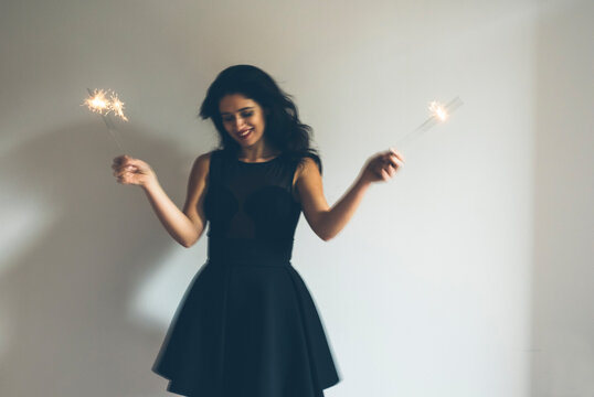 Happy woman holding sparkler during a party