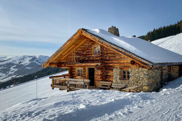 Snow covered mountain hut old farmhouse in the Austrian alps against sky.
