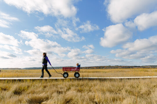 Mother with pulling Child with Wagon Landscape