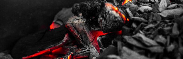 Red hot coal nugget on focus on other cold raw nuggets of coal. Background of raw coals with soft focus exclusion with color and temperature. Banner