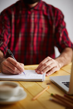 Designer's hands drawing in a notebook
