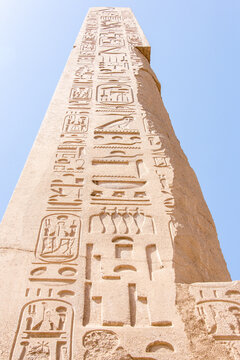 A tall obelisk in Egypt with carved hieroglyphic writing.