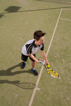 High angle view of young male serving a tennis ball