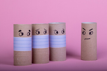 four empty toilet paper rolls, three with face mask looking to one without mouth protection
