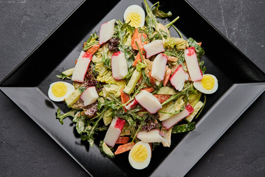 Crab stick salad with fresh vegetable and eggs.