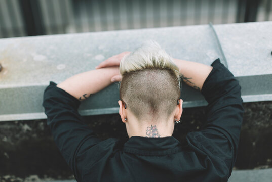 tired blond woman with mohawk from behind