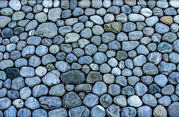 Handmade wall surface. background of large rounded gray stones, pebbles, copy space