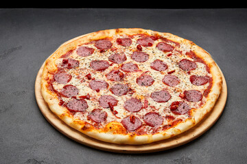 Delicious Italian Pizza pepperoni with mozzarella cheese and salami on dark background