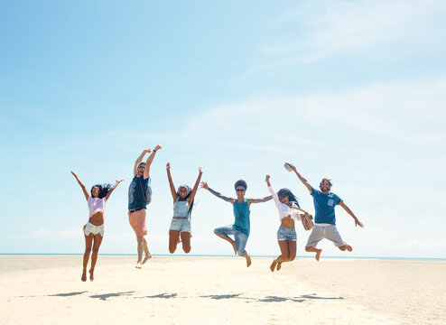 Group of Happy People Jumping on a Tropical Beach