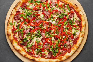 Pizza with a large number of toppings: hunting sausages, onions, cheese and bell pepper