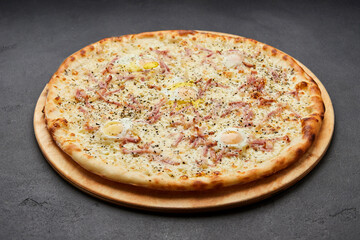 Delicious Italian Pizza Carbonara with Bacon, eggs and mozzarella cheese on dark background