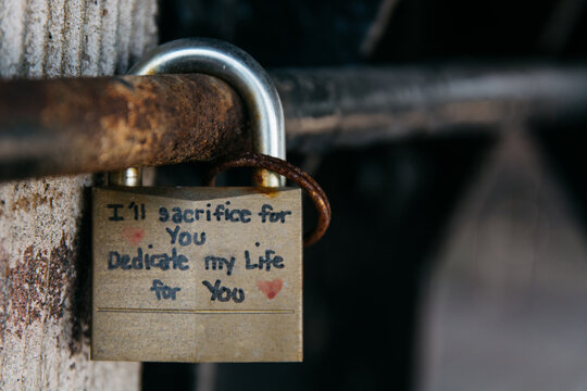 Rusty padlock with a dedication promise written on it