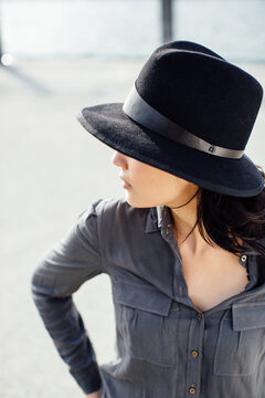 Profile of young brunette woman with hat