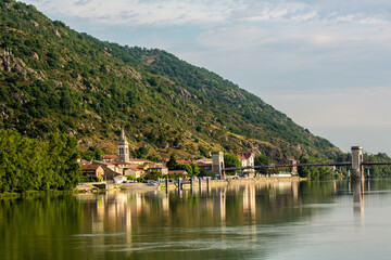 Fototapeta na wymiar A bridge across tghe Rhone River and the commune of Andance, France