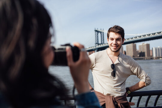 Smiling young man photographed by his girl friend outdoors