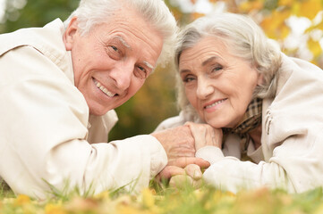 Portrait of beautiful senior couple lying in park