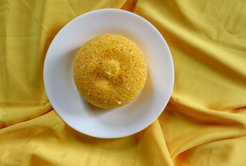 Brazilian Couscous (Cuscuz Brasileiro) on yellow background. Typical Northeast Brazilian dish.