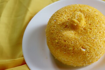 Brazilian Couscous (Cuscuz Brasileiro) on yellow background. Typical Northeast Brazilian dish.