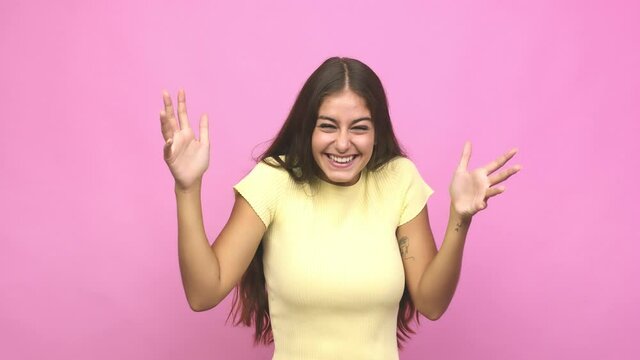 Young caucasian woman receiving a pleasant surprise, excited and raising hands