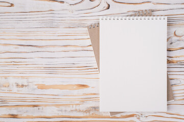 Top above overhead view flat lay photo of a blank notebook placed to the right side isolated on light wooden background with copyspace