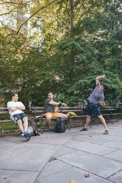 Young Men Friends Hanging Out in New York Park Stretching before Healthy Excercise