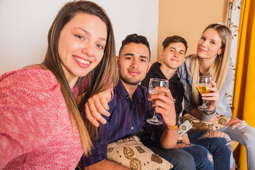 Obraz premium Group of friends enjoying the moment. Young friends take a picture. The focus is on the man in the middle.