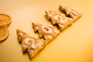 Gingerbread cookies on golden background. 2021 numbers. New year greeting card. Dried orange slices. Christmas trees 